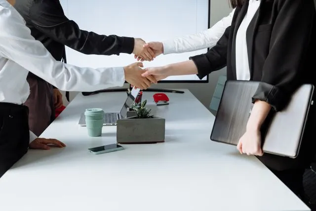 Profissionais se cumprimentando em ambiente de trabalho